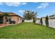 The backyard features a well maintained lawn, privacy fence, and mature trees at 1220 Emerald Hill Way, Valrico, FL 33594