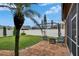 Backyard showcasing brick patio, green lawn, privacy fence, and palm trees at 1220 Emerald Hill Way, Valrico, FL 33594