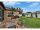 This backyard has a brick patio with a fire pit and seating, lush lawn and a barbecue grill at 1220 Emerald Hill Way, Valrico, FL 33594