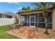 A brick patio with comfortable seating is perfect for relaxing with views of the tropical landscaping at 1220 Emerald Hill Way, Valrico, FL 33594