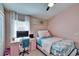 Bedroom features a bed with a blue floral patterened blanket and a desk at 1220 Emerald Hill Way, Valrico, FL 33594