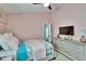 This cozy bedroom includes a ceiling fan, a TV, a dresser, and neutral walls at 1220 Emerald Hill Way, Valrico, FL 33594