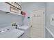 Well-organized laundry room with washer, dryer, shelving, and storage space, designed for convenience and efficiency at 1220 Emerald Hill Way, Valrico, FL 33594