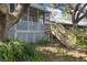 Charming back porch with wooden stairs, lattice, and views of the lush backyard at 12227 Noreast Lake Dr, Tampa, FL 33612