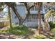Charming blue two-story home with a screened porch, surrounded by mature trees and lush landscaping in the backyard at 12227 Noreast Lake Dr, Tampa, FL 33612