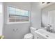 Bright bathroom featuring a toilet, sink, and a window at 12227 Noreast Lake Dr, Tampa, FL 33612
