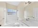 Clean bathroom with a tub, shower, white tile, large mirror, and a bright window providing natural light at 12227 Noreast Lake Dr, Tampa, FL 33612
