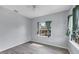 Cozy bedroom with light gray walls, wood-look floors, a ceiling fan, and a window with peaceful outdoor views at 12227 Noreast Lake Dr, Tampa, FL 33612
