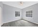 Serene bedroom with light gray walls, wood-look floors and two large windows offering ample natural light at 12227 Noreast Lake Dr, Tampa, FL 33612
