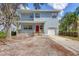 Charming two-story home with light blue siding, red door, a front porch and attached garage at 12227 Noreast Lake Dr, Tampa, FL 33612