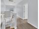 Bright hallway featuring wood-look floors, light walls, natural light from the stairway window and an open doorway at 12227 Noreast Lake Dr, Tampa, FL 33612
