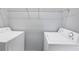 Bright laundry room with washer, dryer, and wire shelving at 12227 Noreast Lake Dr, Tampa, FL 33612