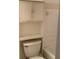 A view of a toilet and open shelving in a bathroom with tiled walls at 12403 Hibiscus Oak Pl # 202, Tampa, FL 33612
