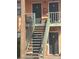 The image displays an exterior staircase with secure railings, and dark painted doors at 12403 Hibiscus Oak Pl # 202, Tampa, FL 33612