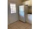 Functional kitchen space with tile flooring, white refrigerator, and exterior door at 12403 Hibiscus Oak Pl # 202, Tampa, FL 33612