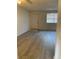 Living area with wood-look flooring, door and window providing natural light at 12403 Hibiscus Oak Pl # 202, Tampa, FL 33612