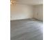 Bright living room featuring wood vinyl flooring, fresh paint, and a front door at 12403 Hibiscus Oak Pl # 202, Tampa, FL 33612