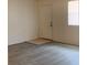 Bright living room featuring wood vinyl flooring, fresh paint, and a front door at 12403 Hibiscus Oak Pl # 202, Tampa, FL 33612