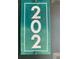 Close-up of the green unit number 202 affixed to a door at 12403 Hibiscus Oak Pl # 202, Tampa, FL 33612