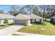 Charming single-story home featuring a well-manicured lawn, neutral color palette, and an attached two-car garage at 13134 Precept Way, Hudson, FL 34669