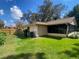 Backyard features a lush lawn, mature trees, and a screened-in porch, creating a private outdoor retreat at 13304 Meadowwood Ct, Tampa, FL 33618