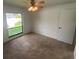 Bright bedroom featuring a ceiling fan and a large window overlooking the yard at 13304 Meadowwood Ct, Tampa, FL 33618