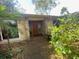 Well-maintained front entryway with stone accents, lush landscaping, and a wood front door at 13304 Meadowwood Ct, Tampa, FL 33618