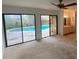 Bedroom with sliding glass doors to the pool area, neutral carpet, and en suite bath at 13304 Meadowwood Ct, Tampa, FL 33618