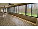 Spacious sun room features tile flooring, large windows providing backyard views, and ceiling fans for comfort at 13304 Meadowwood Ct, Tampa, FL 33618