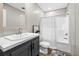 Modern bathroom with a gray vanity, dual sinks, and a shower-tub combo at 14311 Action St, Brooksville, FL 34613