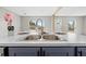 Kitchen island features a stainless steel sink with modern fixtures and gray cabinetry at 14311 Action St, Brooksville, FL 34613