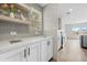 Pantry with white cabinets and light wood shelves and adjacent kitchen at 14311 Action St, Brooksville, FL 34613