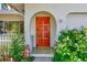 Close-up of the arched front door featuring an ornate wood design and inviting curb appeal at 1831 Kay Dr, Largo, FL 33770