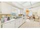 Bright kitchen features white cabinets, tile countertops, and a large window overlooking the backyard at 1831 Kay Dr, Largo, FL 33770