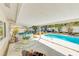 Covered patio featuring outdoor seating, dining area, spa, and a view of the refreshing swimming pool at 1831 Kay Dr, Largo, FL 33770