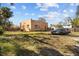 Large backyard with orange stucco home, grass, and mature trees, perfect for outdoor activities at 1900 17Th S St, St Petersburg, FL 33712