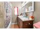 Well-lit bathroom featuring a double sink vanity and shower with colorful curtain at 1900 17Th S St, St Petersburg, FL 33712