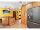 Bright kitchen with wood cabinets, a gray stainless steel refrigerator, and a breakfast bar at 2503 Withy Ct, Tampa, FL 33618