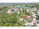 Aerial view of home in a community close to a lake and featuring mature trees at 2504 Woodcote Ter, Palm Harbor, FL 34685