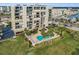 Aerial view of condo complex and community pool surrounded by landscaping at 2530 Gary Cir # 401, Dunedin, FL 34698