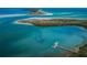A stunning aerial view of a serene island surrounded by clear blue water and a boat dock at 2530 Gary Cir # 401, Dunedin, FL 34698