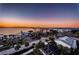 Sunset view from a condo with palm trees, parking, and a glimpse of the pier creates a serene coastal ambiance at 2530 Gary Cir # 401, Dunedin, FL 34698