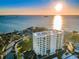 Aerial view of the Marina Tower condo building with a view of the ocean and waterfront property at sunset at 2530 Gary Cir # 401, Dunedin, FL 34698