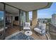 Comfortable balcony seating with cushions and a small table offers views of the water and palm trees at 2530 Gary Cir # 401, Dunedin, FL 34698