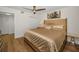Bright bedroom with a modern ceiling fan, hardwood floors, and closet in the hall at 2530 Gary Cir # 401, Dunedin, FL 34698