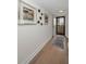 Hallway view of condo unit with wood floors, artwork, and view of the balcony and sky at 2530 Gary Cir # 401, Dunedin, FL 34698