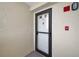 Hallway view of condo unit with a white door, black hardware, and gray flooring at 2530 Gary Cir # 401, Dunedin, FL 34698