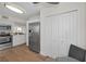 Modern kitchen featuring stainless steel appliances, white cabinetry, and hardwood floors, adjacent to dining area at 2530 Gary Cir # 401, Dunedin, FL 34698