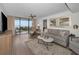 Bright living room with hardwood floors, modern decor, and a large sliding glass door to the water view balcony at 2530 Gary Cir # 401, Dunedin, FL 34698