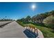 A tranquil wooden bench by a scenic walking path with lush green grass and tropical trees at 2530 Gary Cir # 401, Dunedin, FL 34698